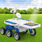 White and blue solar Mars exploration car toy on grass with black rubber tires and solar roof.