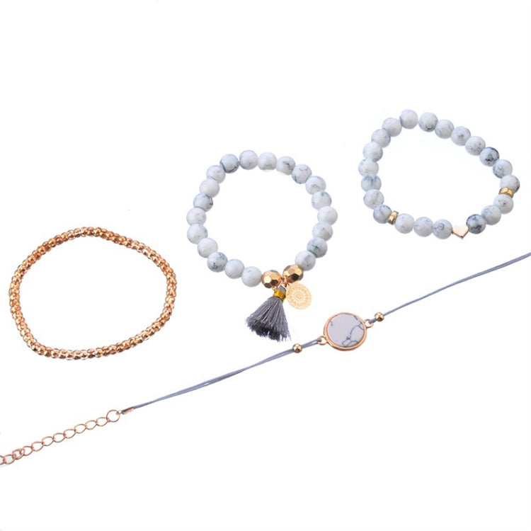 Bracelet set with white bead bangles, rose-gold chain bracelet, and round marble-style charm