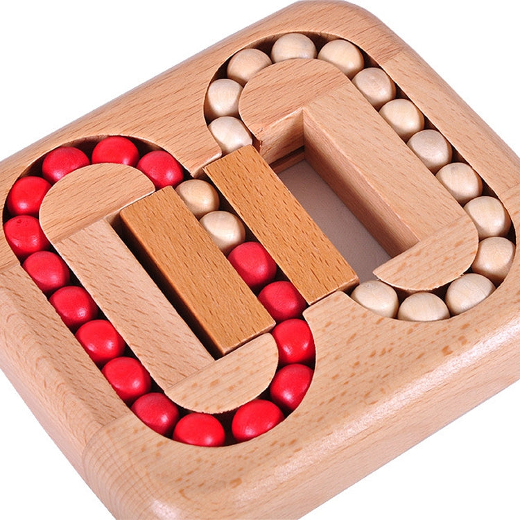 Close-up wooden ball maze with red and white beads in central grooves