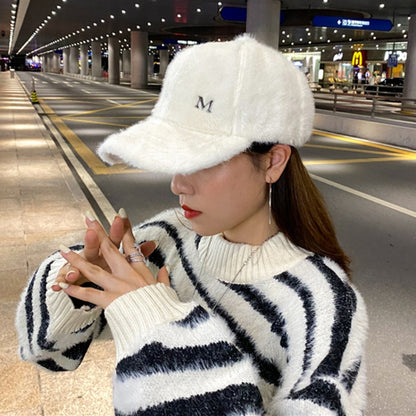 White plush rabbit-fur baseball cap with curved brim and small M logo