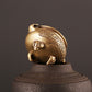 Antique brass censer furnace close-up, face-like ornament and pedestal base texture.