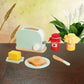 Mint bread maker toy with sliced toast pieces and red and yellow drink cups