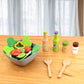 Pretend salad bowl set with vegetable pieces, spice bottles, and wooden utensils