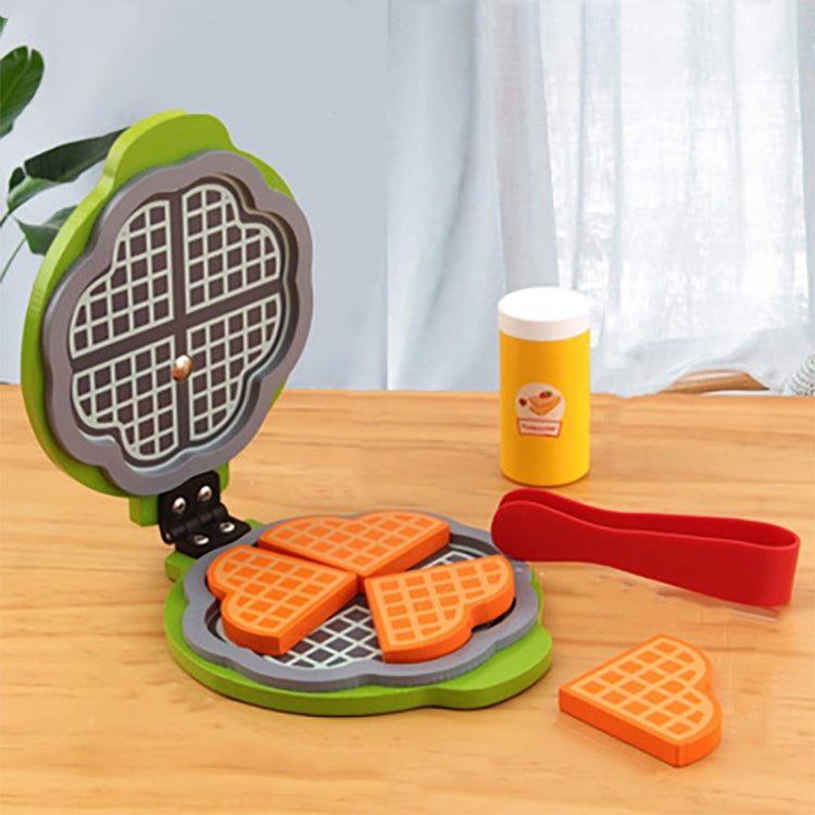 Waffle maker toy with orange grid waffles, red spatula, and topping pieces