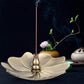Flower-shaped gold incense burner tray with incense stick and central cone
