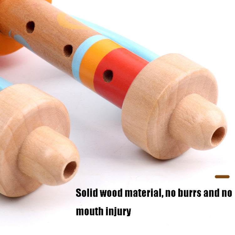 Close-up of wooden horn whistle toy with perforated light wood tube and red-blue bands.
