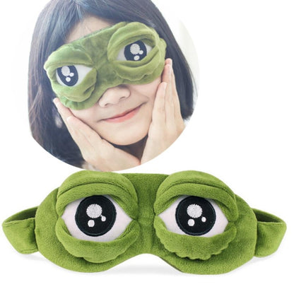 Green frog plush eye mask with 3D cartoon eyes, worn by person