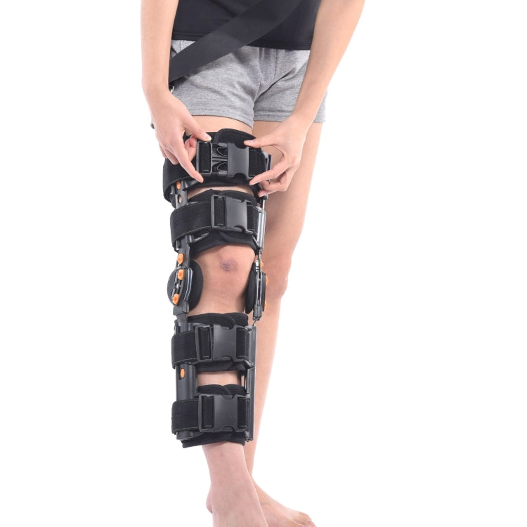 Adjustable black knee brace close-up with padded sections and orange hinge details