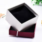 Open jewelry bracelet box with white exterior and black fabric interior lining.