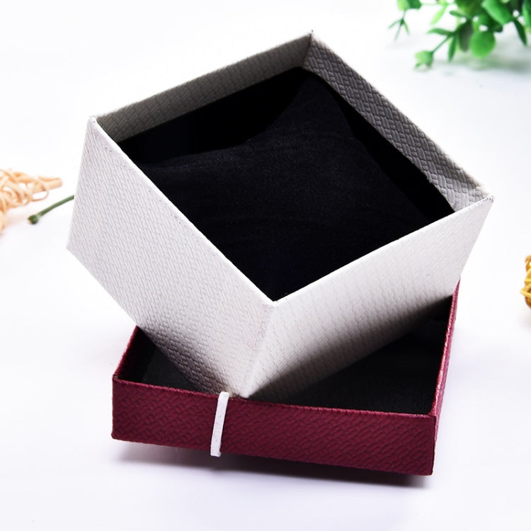 Open jewelry bracelet box with white exterior and black fabric interior lining.