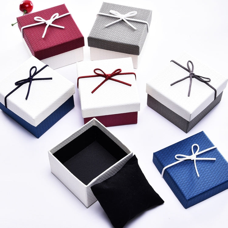 Assorted jewelry gift boxes with ribbon bows; one open box shows black interior.