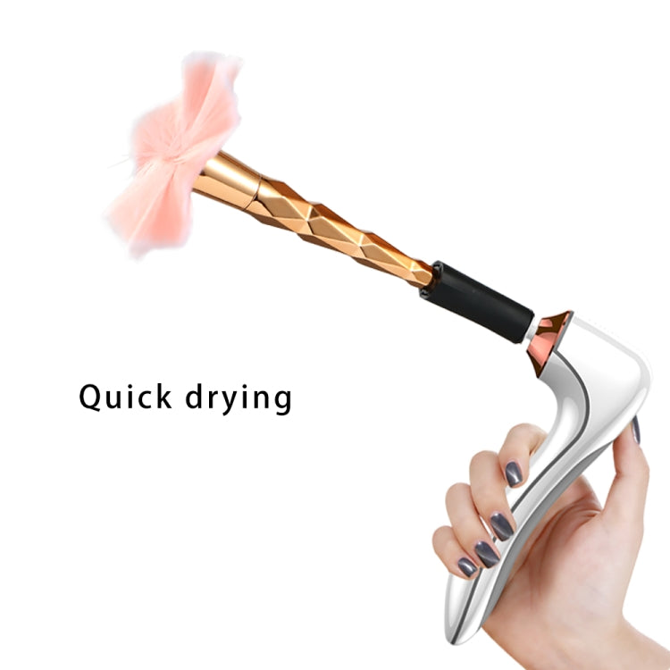 Hand using white makeup brush cleaner and dryer, copper nozzle with brush head for drying
