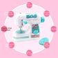 White and turquoise toy electric sewing machine with colorful bobbins and accessory compartments
