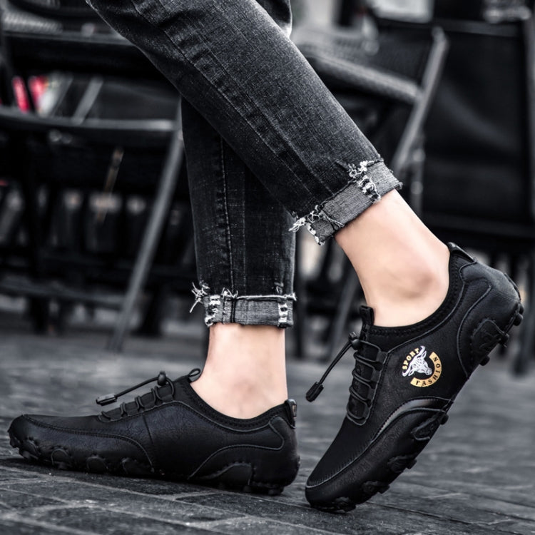 Black leather casual sneakers with strap closure and rugged rubber tread sole