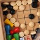 Close-up wooden board game with colored pawns, wooden marbles, and black grid lines