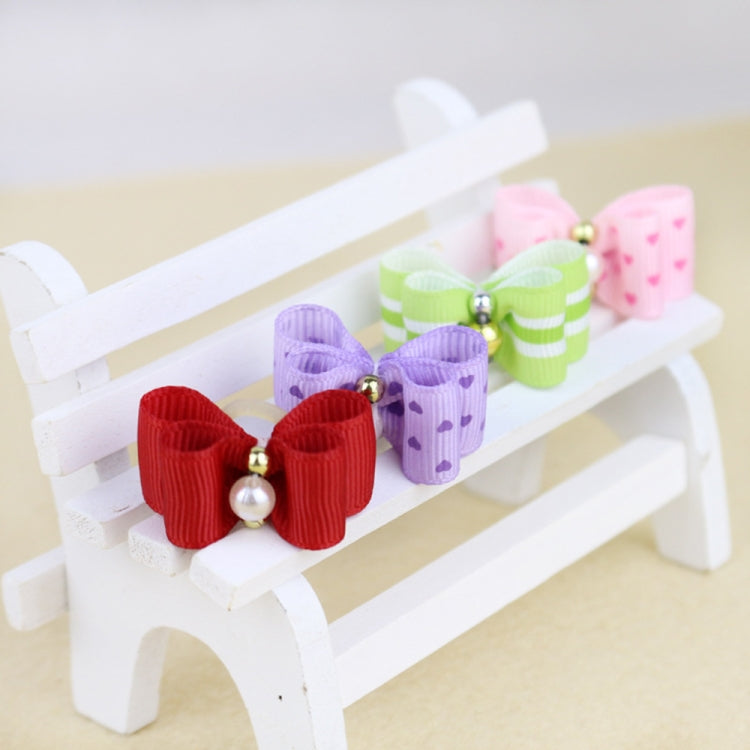 Red double-layer ribbon dog bow tie with pearl bead clip, shown in a close-up circle