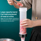 Sausage stuffer with tall barrel holding raw meat mixture, gripped by hands