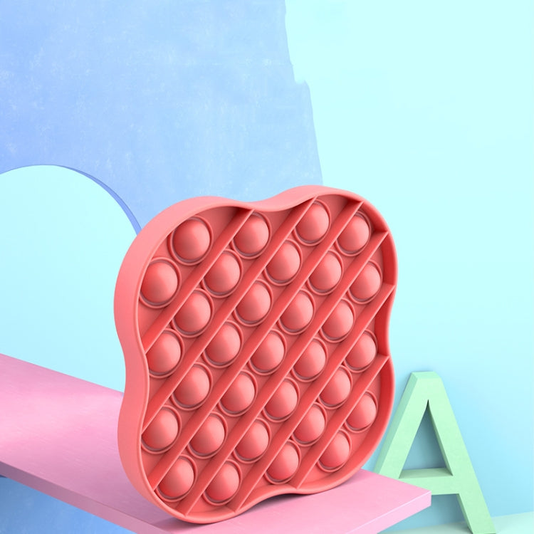 Pink silicone pop-it pressing board close-up with raised bubble pattern