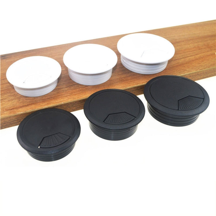 Assorted round desk cable hole covers, white and black ABS lids on wood