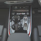 Car center console with red gear shift side trim strips framing the gear area