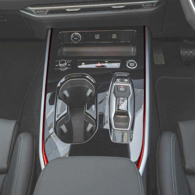 Car center console with red gear shift side trim strips framing the gear area