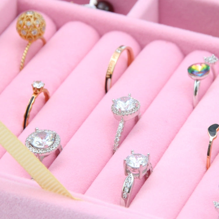 Jewelry pieces arranged in pink grid compartments inside a flannel storage box