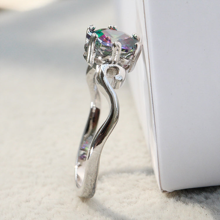 Side view of sterling silver ring with prong-set multicolor faceted gemstone on a curved band