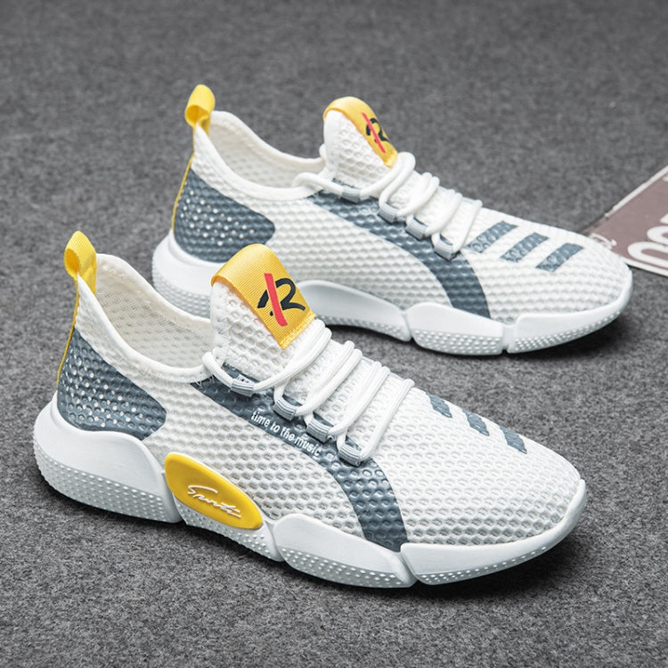 Pair of white mesh knit running shoes with dark blue panels and yellow lace tips