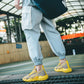 Yellow and gray breathable running shoes with chunky sole and side logo patch