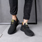 Black running sneakers on feet, lace-up with yellow accents