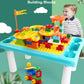 Kids' building table with colorful blocks on top; child playing beside the table
