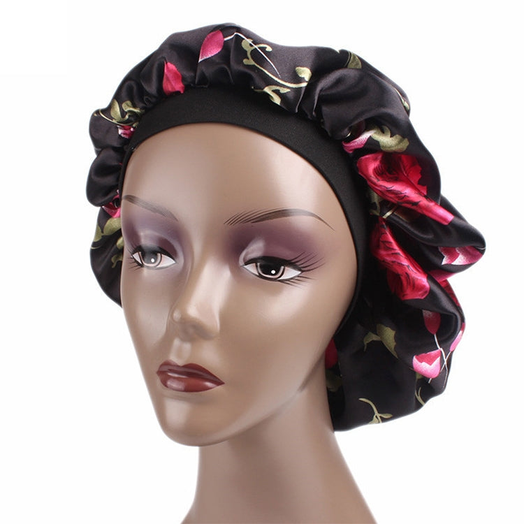 Women’s satin hair bonnet in black with pink rose floral pattern and gathered elastic band