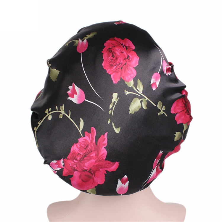 Women’s satin hair bonnet in black with magenta flower print and black elastic band
