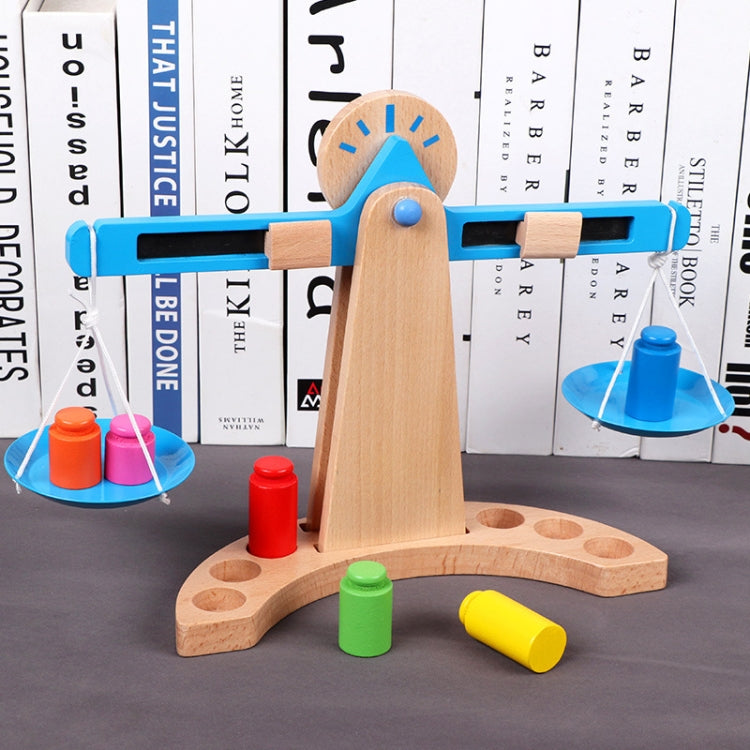 Wooden balance scale toy with blue base, colored cylinders, and hanging plate weights