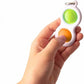 Finger fidget keychain held in hand, white with green and orange press pads