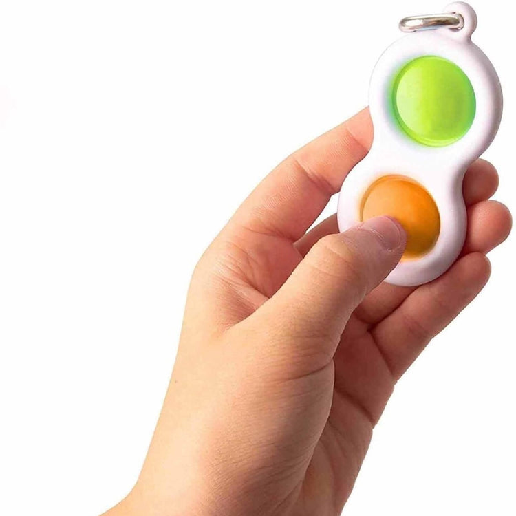 Finger fidget keychain held in hand, white with green and orange press pads