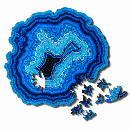 Wooden jigsaw puzzle with blue agate-style pattern and scattered puzzle pieces