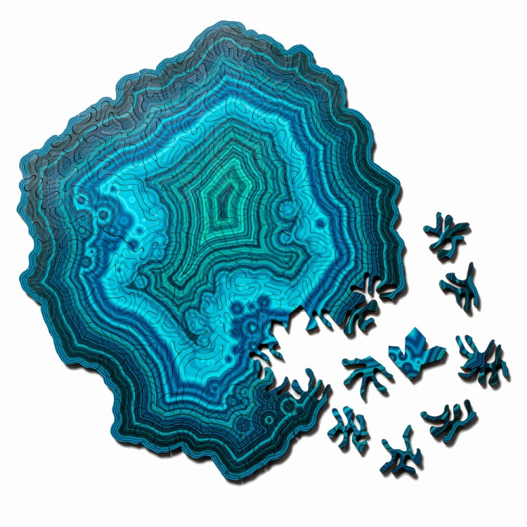 Wooden jigsaw puzzle with blue-green agate-style pattern and scattered puzzle pieces