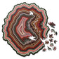 Wooden jigsaw puzzle with multicolor agate-style pattern and scattered puzzle pieces