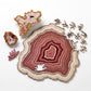 Wooden jigsaw puzzle with pink-and-cream agate-style pattern and scattered pieces