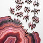 Wooden jigsaw puzzle piece close-up with purple and red agate-style contours
