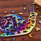 Rainbow wooden snail 3D puzzle on tabletop with small pieces scattered