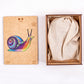 Wooden snail puzzle set in box with illustrated cover and cloth storage bag
