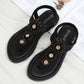 Black flat thong sandals showing beaded floral front strap detail