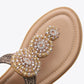 Close-up of tan thong sandal with cluster rhinestone bow and stitched trim