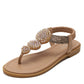 Tan flat thong sandals with embellished floral strap and cushioned footbed