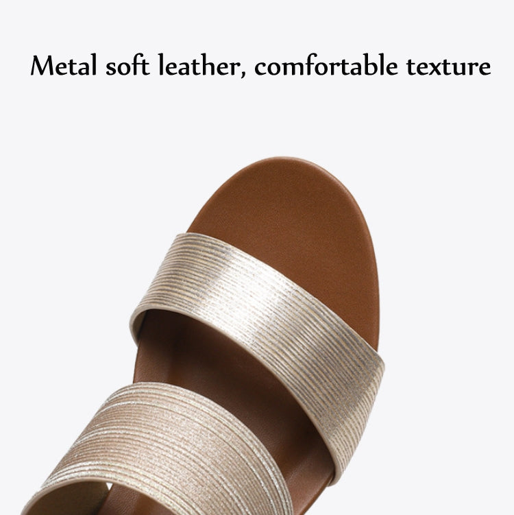 Close-up of champagne shimmery slide sandal upper with wide strap and tan footbed