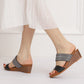 Model wearing gray and dark strap platform wedge slide sandals with open toe