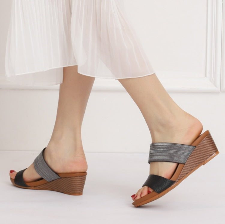 Model wearing gray and dark strap platform wedge slide sandals with open toe
