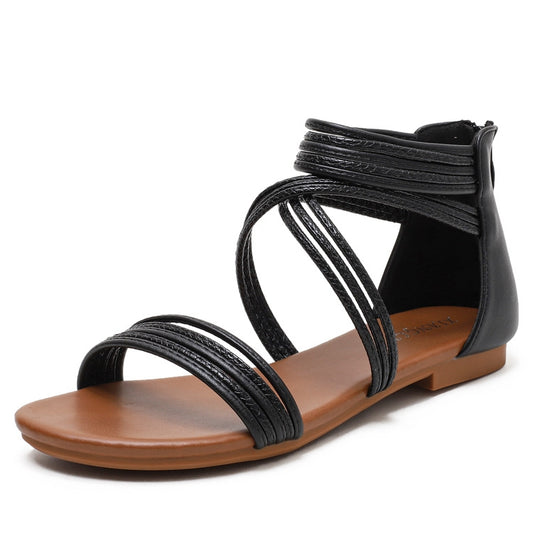Black strappy flat sandal with open toe and ankle wrap strap